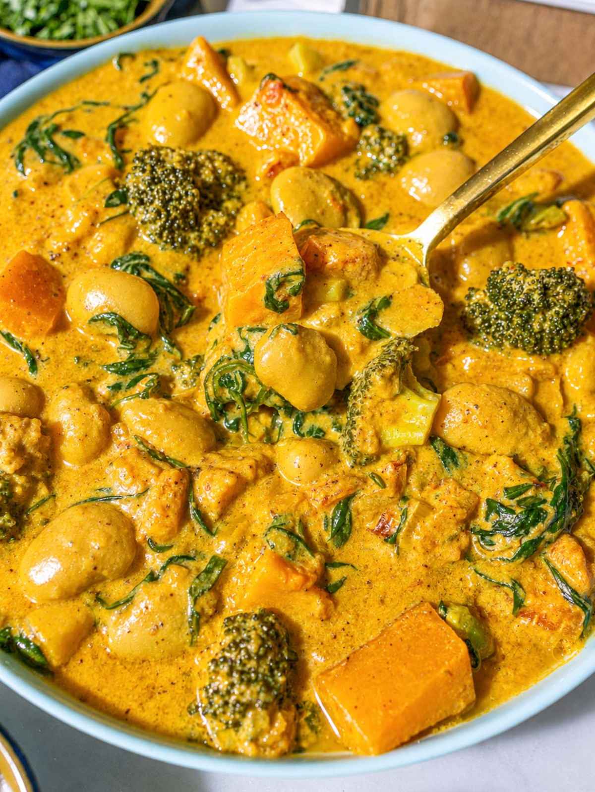 Close-up of tender vegetables coated in a silky Greek yogurt curry sauce.