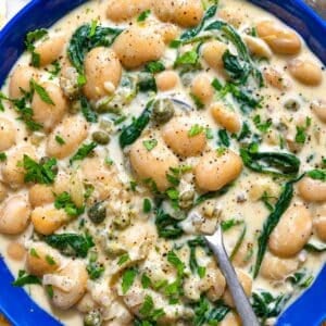 Creamy Piccata Beans with spinach and capers in lemon sauce.