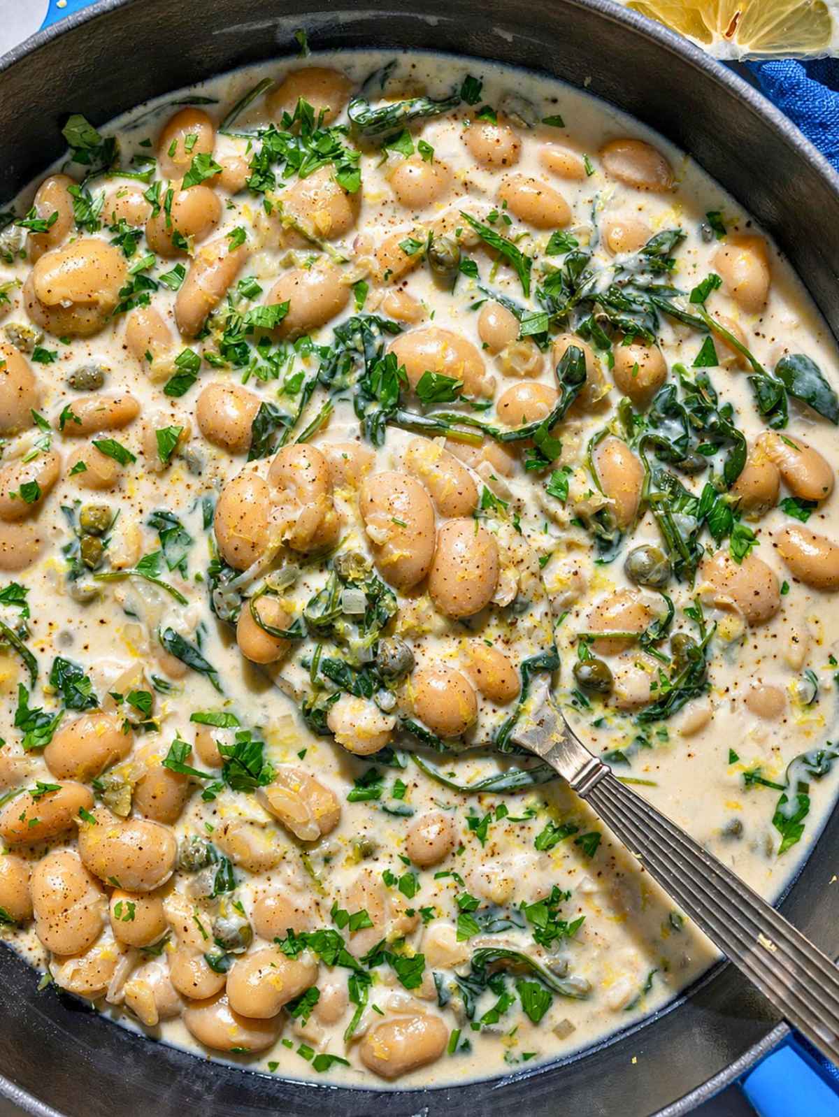 Creamy Piccata Beans with spinach, capers, lemon, and parsley.