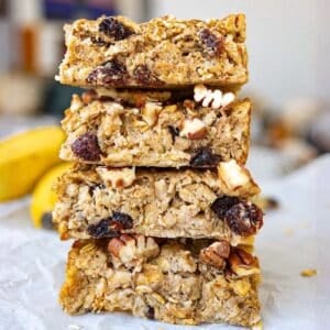 Golden oatmeal raisin baked oatmeal in sliced and stacked on bright countertop.