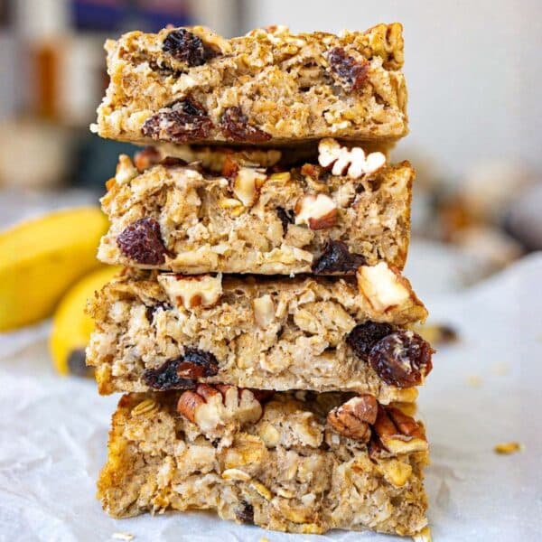 Golden oatmeal raisin baked oatmeal in sliced and stacked on bright countertop.