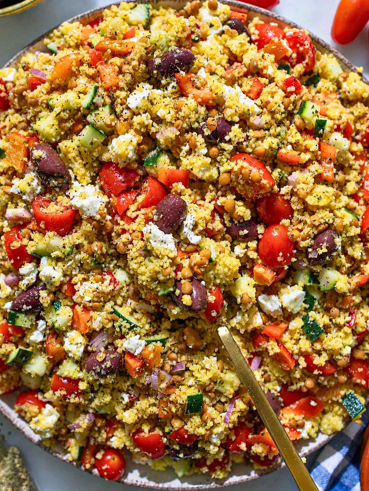 Greek couscous salad with lentils, crisp vegetables, olives, and feta.