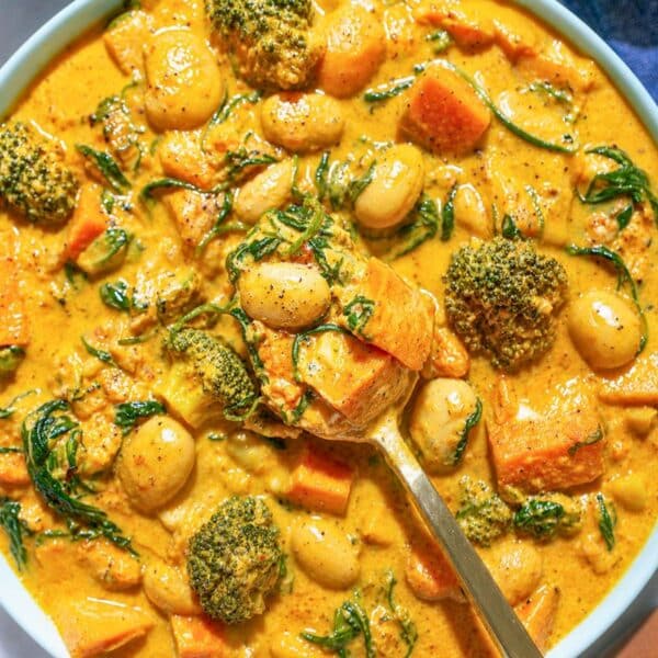 Greek yogurt vegetable curry with a golden spoon, veggies, and creamy yogurt.