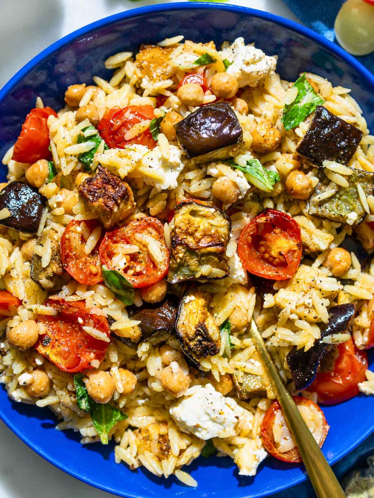 Roasted eggplant orzo with jammy tomatoes, chickpeas, feta, and basil.