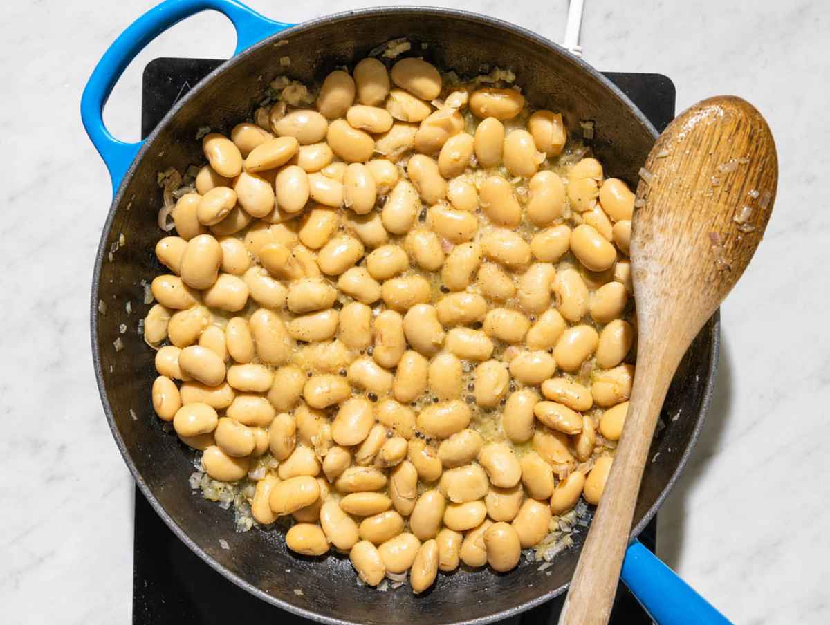 Step 2 Butter beans simmering with white wine, salt, and black pepper.