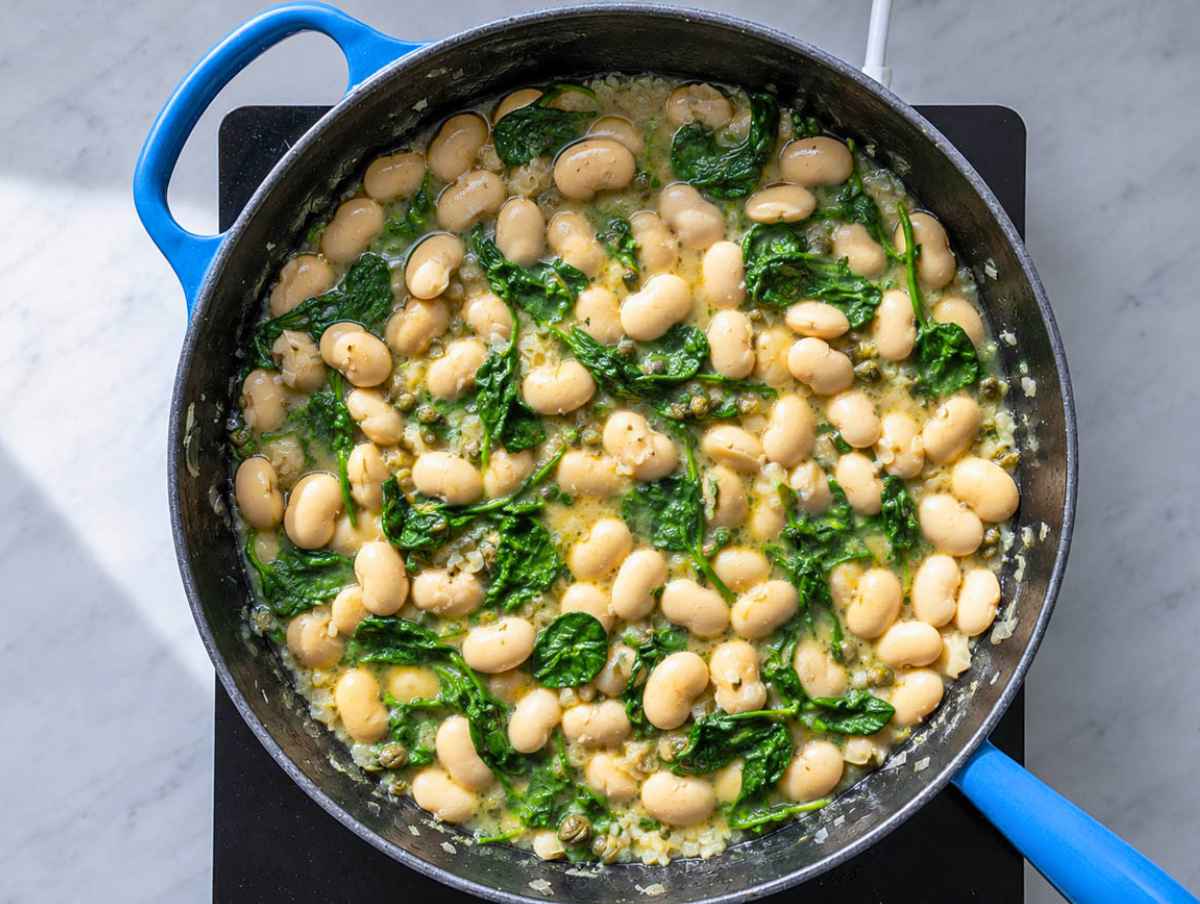 Step 3 Butter beans simmering with capers and wilted baby spinach.