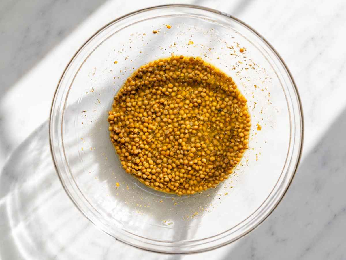 Step 3 Drained lentils marinating in oregano vinaigrette in a large mixing bowl.