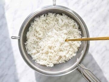 Step 3 Fluffy basmati rice draining in a fine-mesh strainer after cooking.