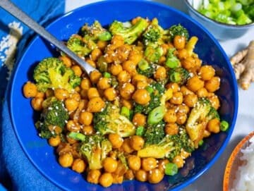 Step 4 Glossy sesame sauce coating chickpeas and broccoli in a blue bowl.