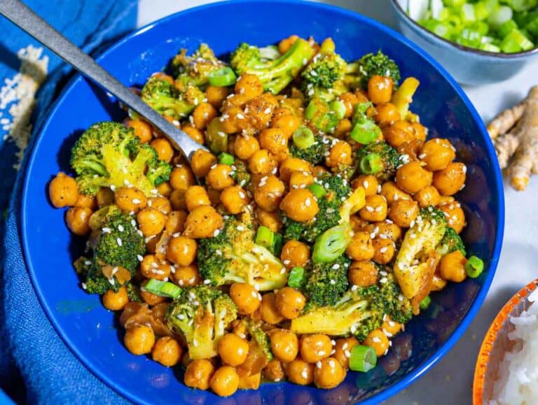 Step 4 Glossy sesame sauce coating chickpeas and broccoli in a blue bowl.