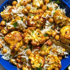 Tandoori cauliflower bowls with golden cauliflower, chickpeas, basmati rice, and golden spoon.