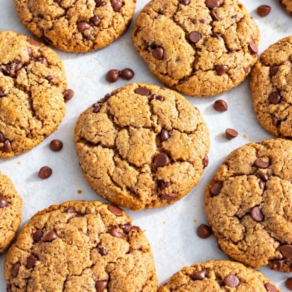 Almond butter chocolate chip cookies together on baking sheet.