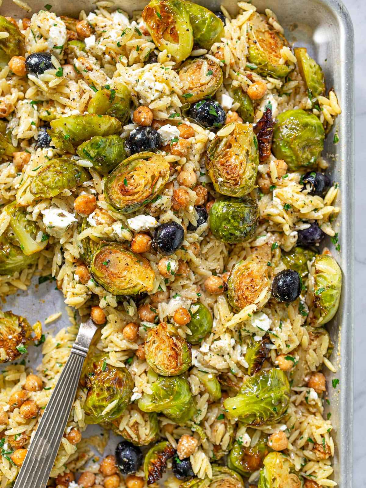 Roasted Brussels sprouts orzo with chickpeas, feta, olives, and parsley.