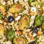 Roasted Brussels sprouts orzo with golden chickpeas, feta, olives, and parsley.