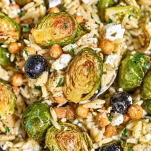 Roasted Brussels sprouts orzo with golden chickpeas, feta, olives, and parsley.
