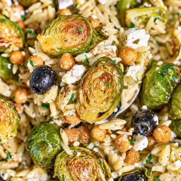 Roasted Brussels sprouts orzo with golden chickpeas, feta, olives, and parsley.
