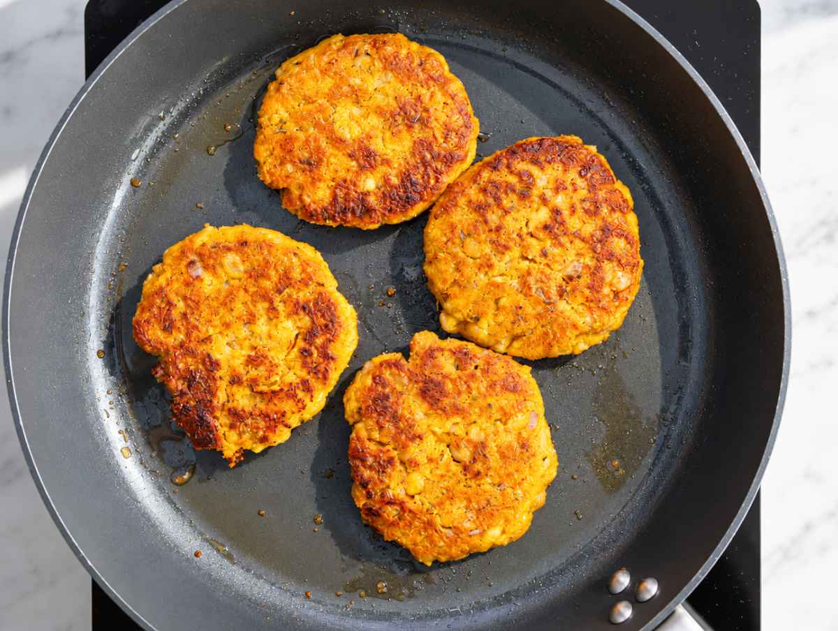 Step 4 Chickpea Butternut Squash Patties cooked in a skillet until golden and crisp.