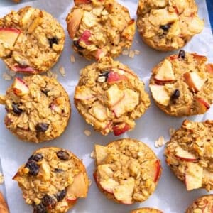Baked apple oatmeal cups with Greek yogurt arranged on baking paper.