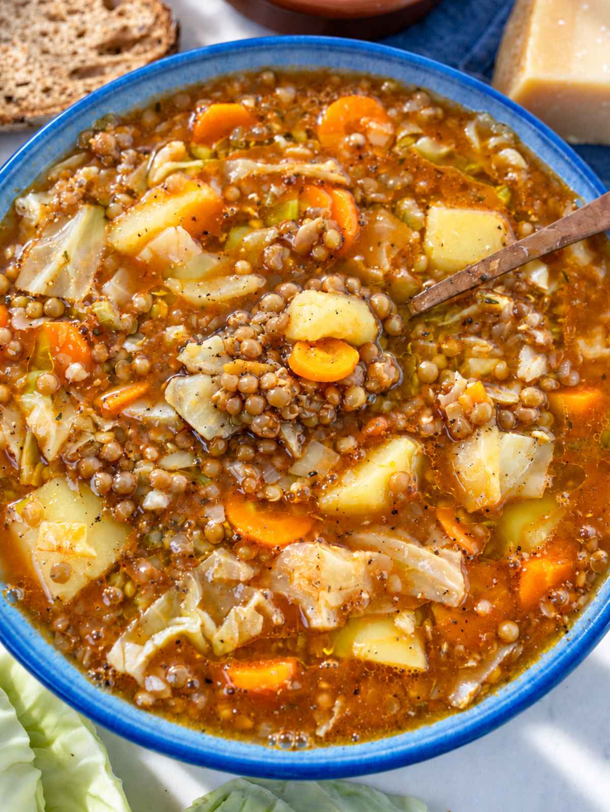 Bowl of cabbage lentil soup with tender vegetables and lentils.