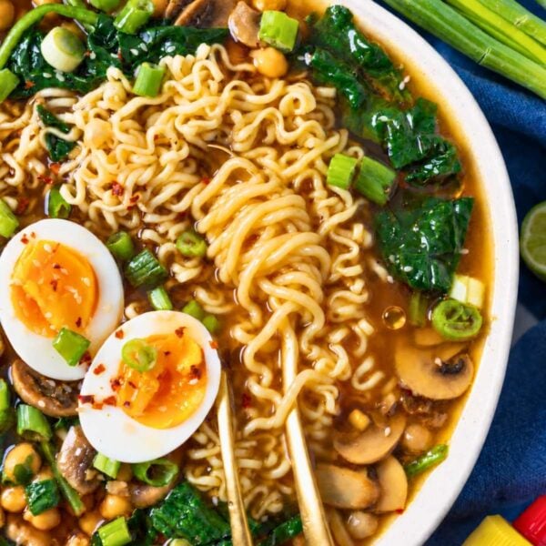Chickpea ramen soup topped with jammy eggs, green onions, and sesame seeds.
