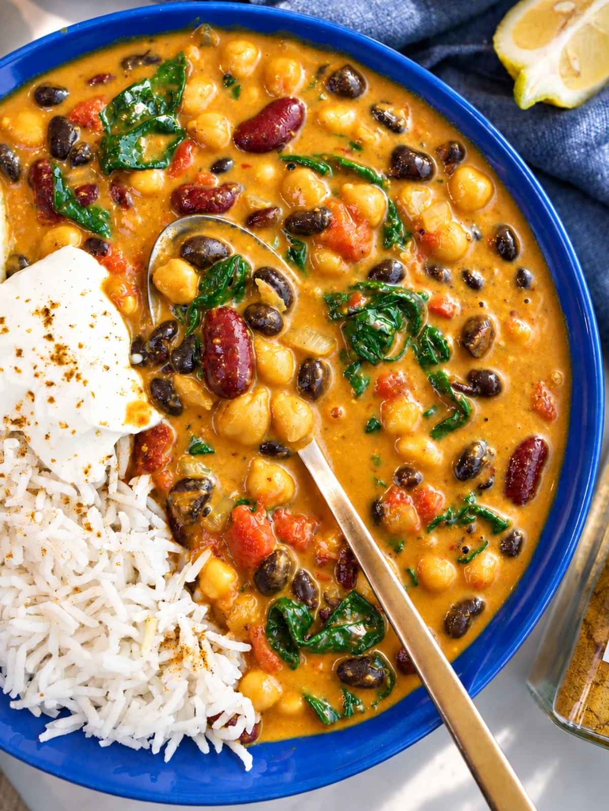Close-up of black beans, kidney beans, and chickpeas in creamy curry sauce.