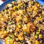 Colorful roasted cauliflower quinoa bowl with black beans and fresh cilantro.