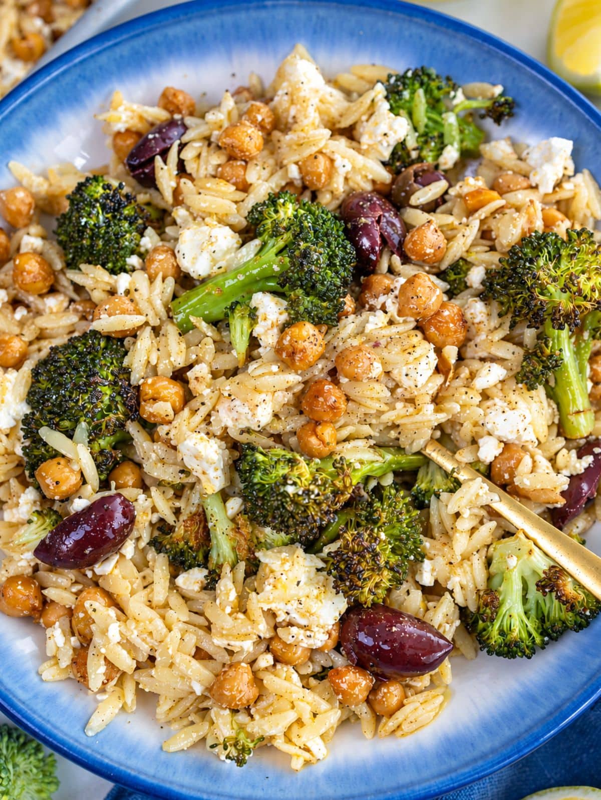 Flat lay of glossy orzo nestled between charred broccoli florets and golden chickpeas.