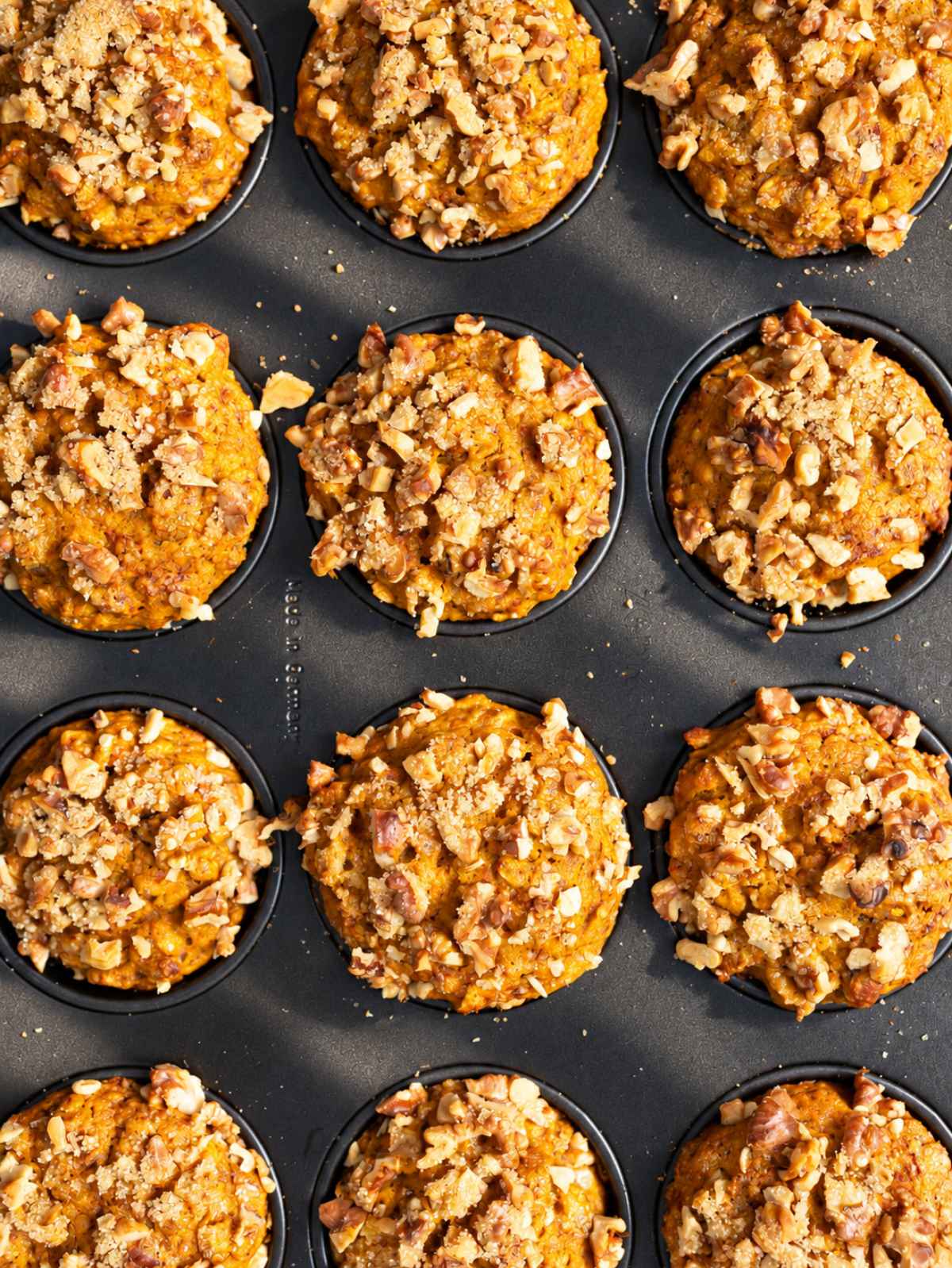 Golden pumpkin oatmeal muffins topped with toasted walnuts.
