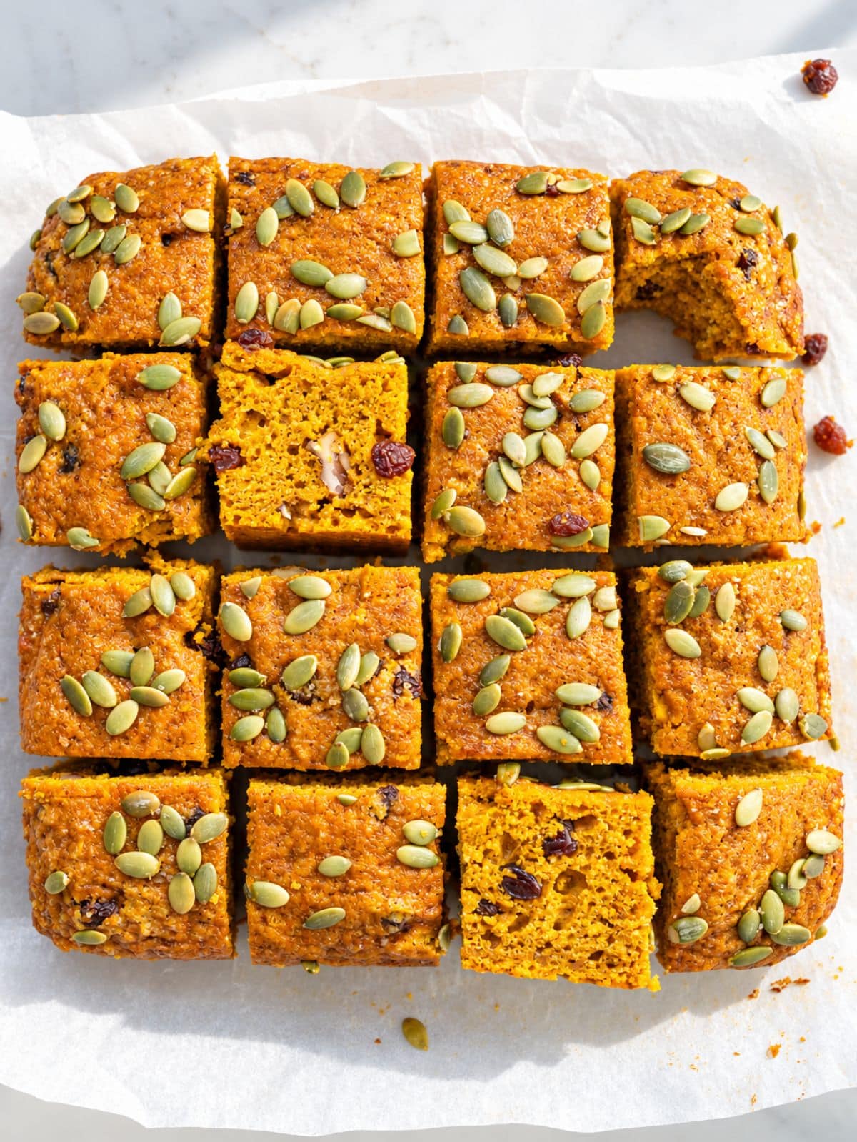 Greek yogurt pumpkin cake squares with moist crumb, raisins, and pumpkin seeds.