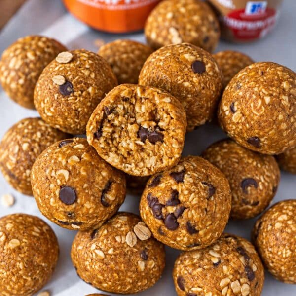 No-bake pumpkin energy balls stacked on parchemtn paper in soft natural light.