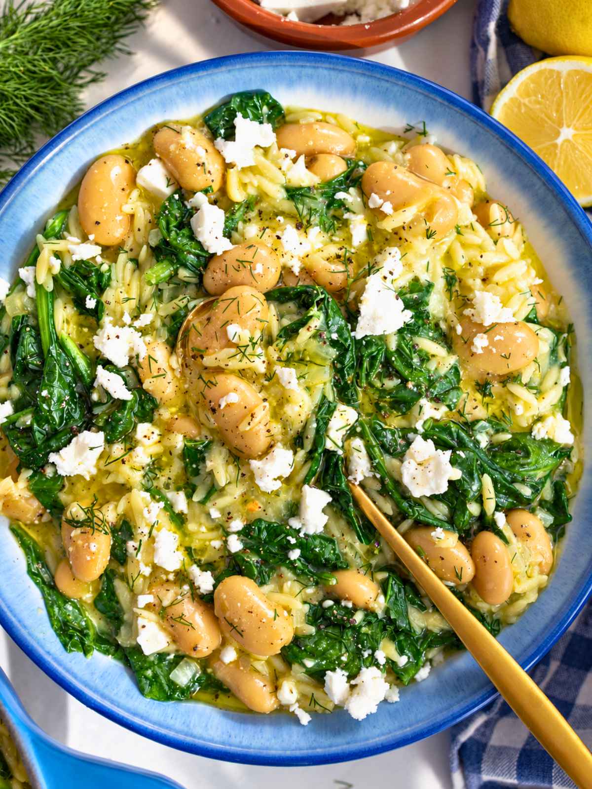 Overhead view of creamy butter beans orzo with spinach, feta, and dill.