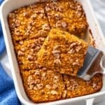 Pumpkin baked oatmeal with golden walnuts in a white ceramic baking dish