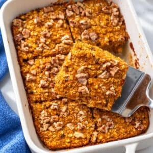 Pumpkin baked oatmeal with golden walnuts in a white ceramic baking dish