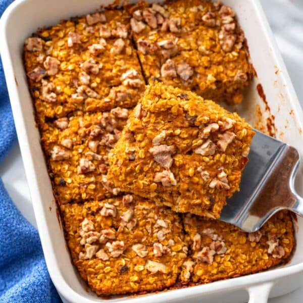 Pumpkin baked oatmeal with golden walnuts in a white ceramic baking dish