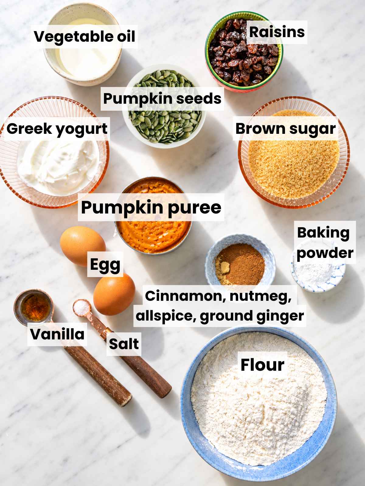 Pumpkin cake ingredients with pumpkin puree, Greek yogurt, flour, eggs, and spices.