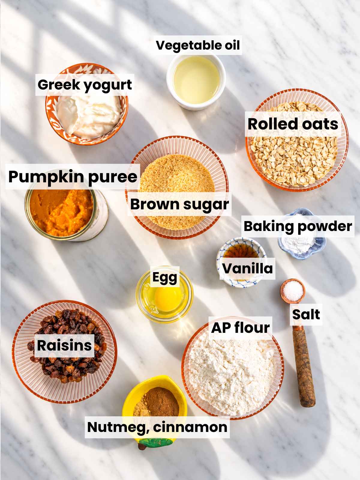 Pumpkin puree, Greek yogurt, oats, spices, and walnuts on marble.