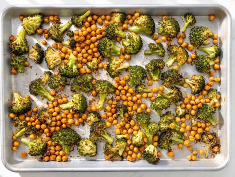 Step 1 Broccoli and chickpeas spread across a sheet pan with paprika seasoning.