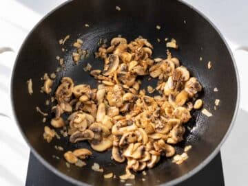 Step 1 Sliced mushrooms and chopped onions sautéing in a large pot.