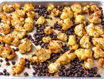 Step 1 – Roasted cauliflower florets and black beans spread across a baking sheet.