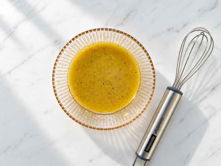 Step 2 Honey mustard dressing in a bowl with garlic and lemon zest.