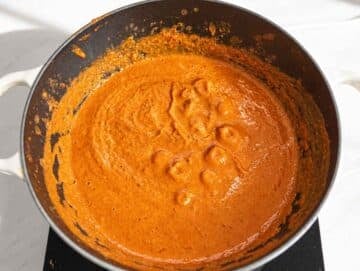 Step 2 Immersion blender combining tomatoes, broth, and black beans into smooth sauce.