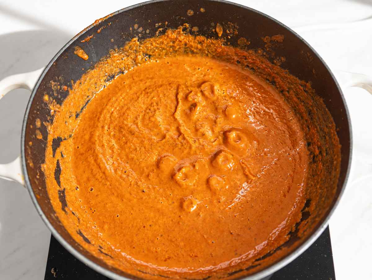 Step 2 Immersion blender combining tomatoes, broth, and black beans into smooth sauce.