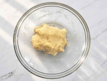 Step 2 Soft almond cookie dough formed into a ball inside a mixing bowl.