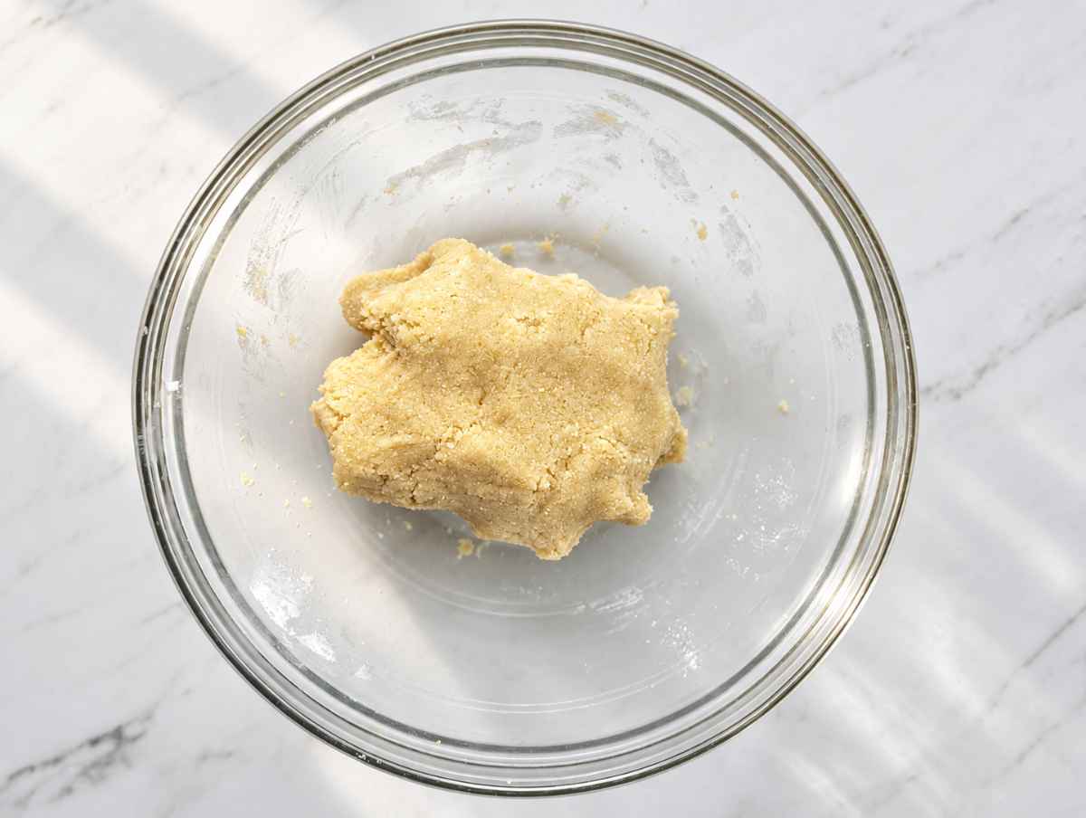 Step 2 Soft almond cookie dough formed into a ball inside a mixing bowl.