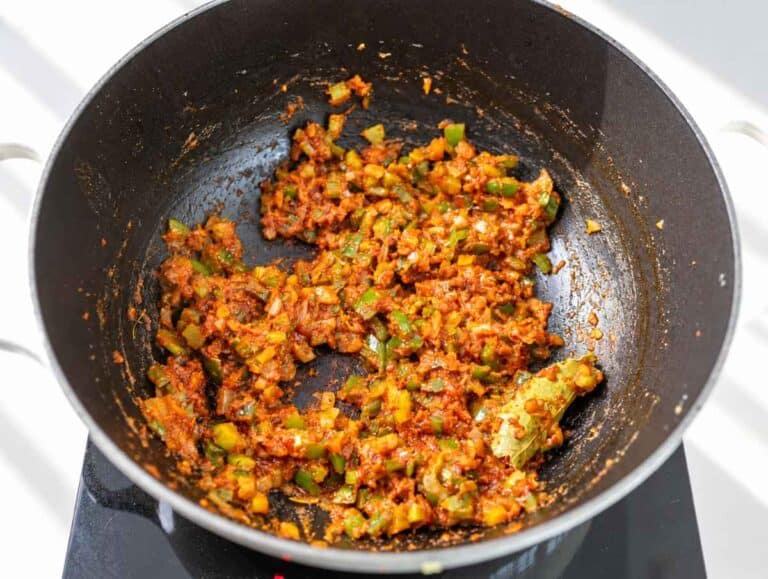 Step 2 Tomato paste, garlic, and Cajun spices stirred into sauteฬed vegetables.