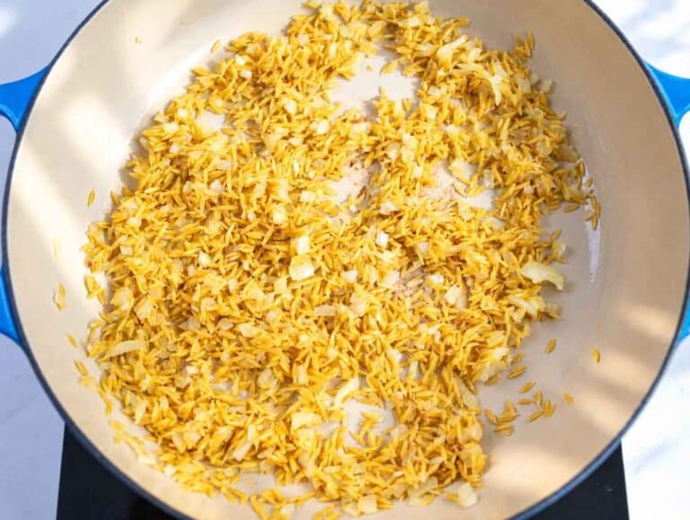 Step 2 Uncooked orzo and grated garlic stirred into softened onions.
