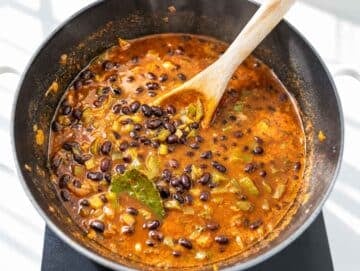 Step 3 Black beans simmering in seasoned broth with vegetables and bay leaf.