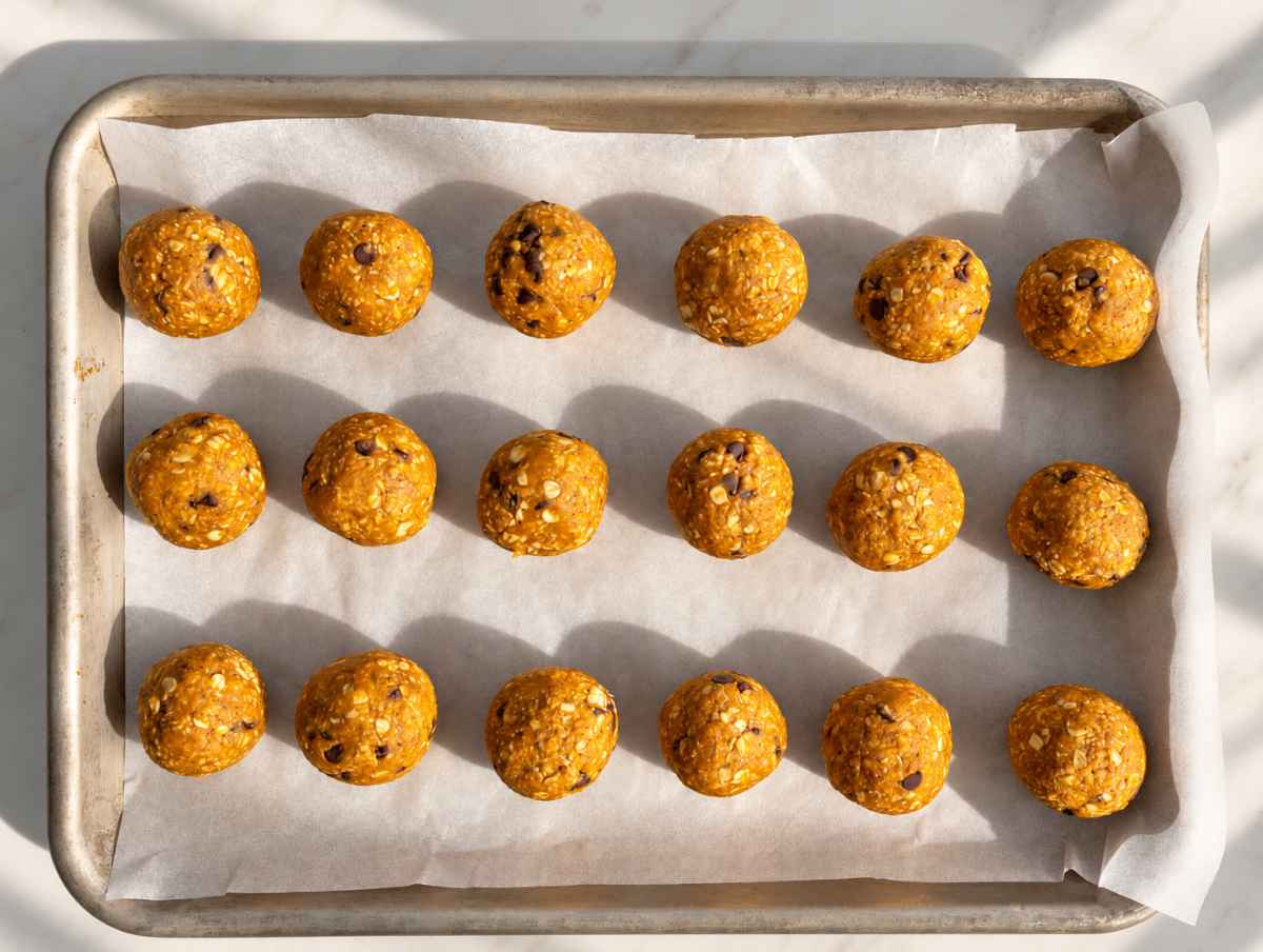 Step 3 - Pumpkin energy balls arranged on parchment paper, ready to chill.