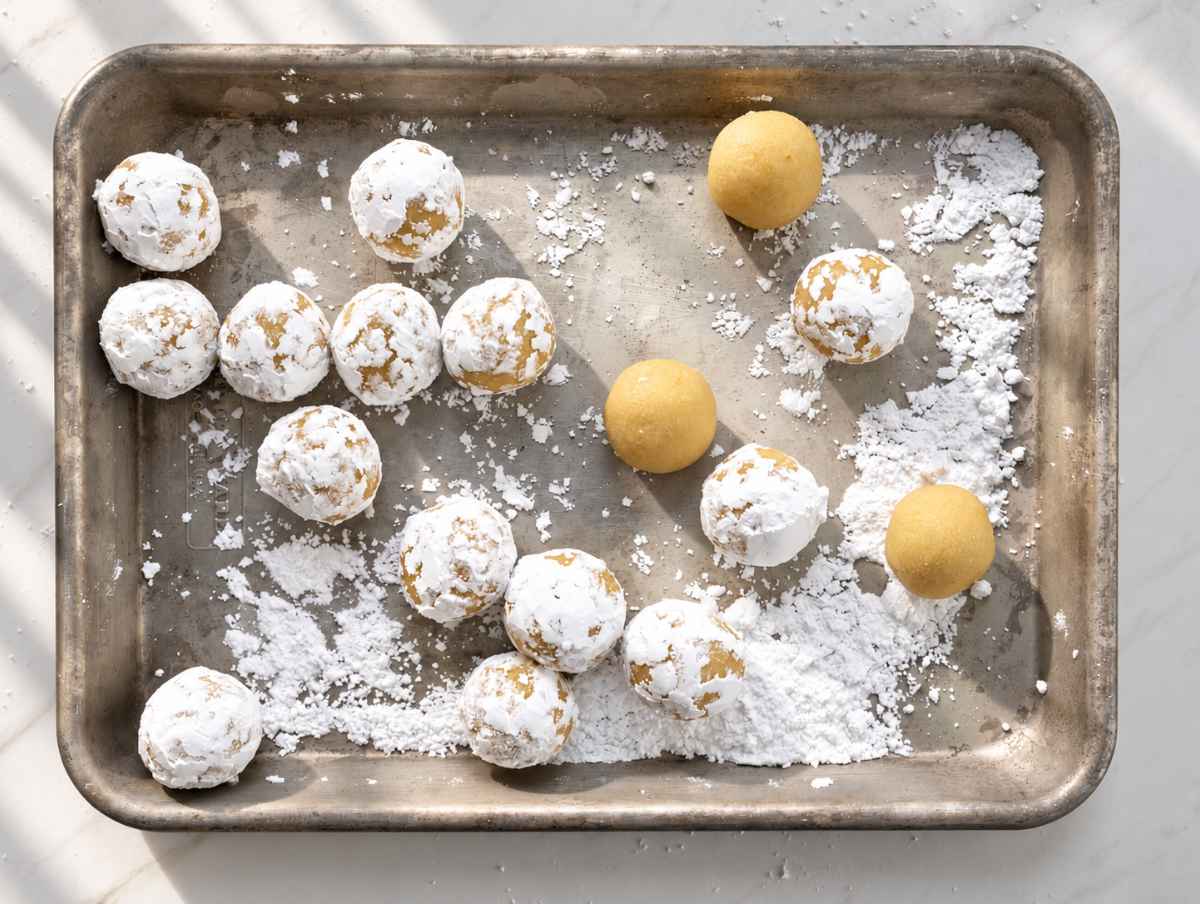 Step 3 Small cookie dough balls coated in powdered sugar on a baking sheet.