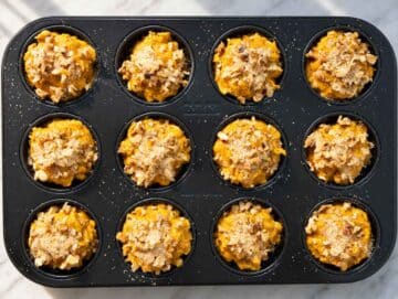 Step 3 Twelve muffin cups filled with pumpkin batter and topped with chopped walnuts.
